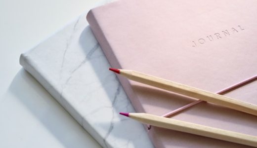 Des carnets de notes et des crayons à papier sont posés. Les couleurs sont lumineuses et pastel.